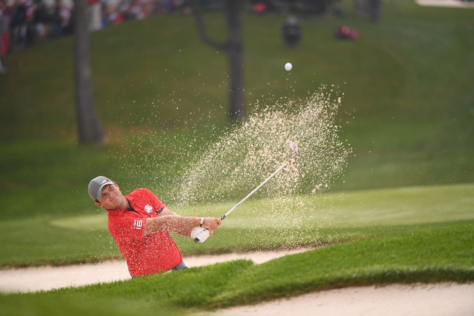 Patrick Reed hits out of a bunker.