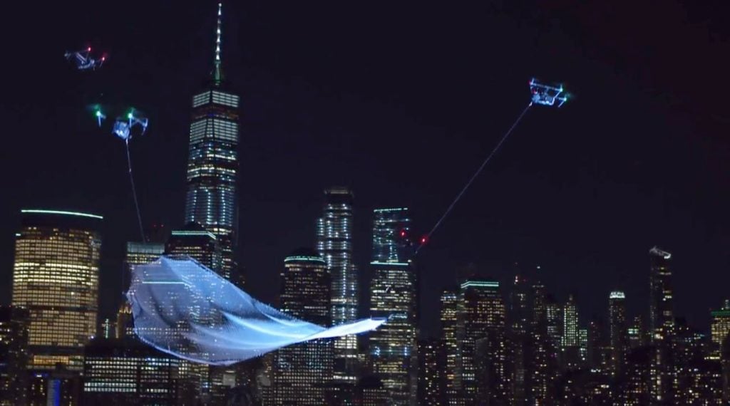 A floating net suspended by drones with the Manhattan skyline as a backdrop.