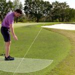 A golfer takes a drop out of the bunker.