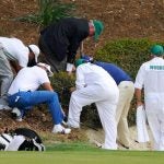 Caddies and officials search for a golf ball at the Masters.