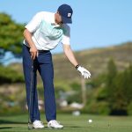 Jordan Spieth makes a drop with Slugger White looking on at the 2019 Sony Open.