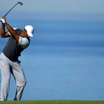 Tiger Woods hits an approach during the first round of the Farmers Insurance Open.