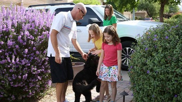 The Kahn family (Amelia, left; Makenzie, right) with Pongo, who is being trained as a service dog to help the girls.