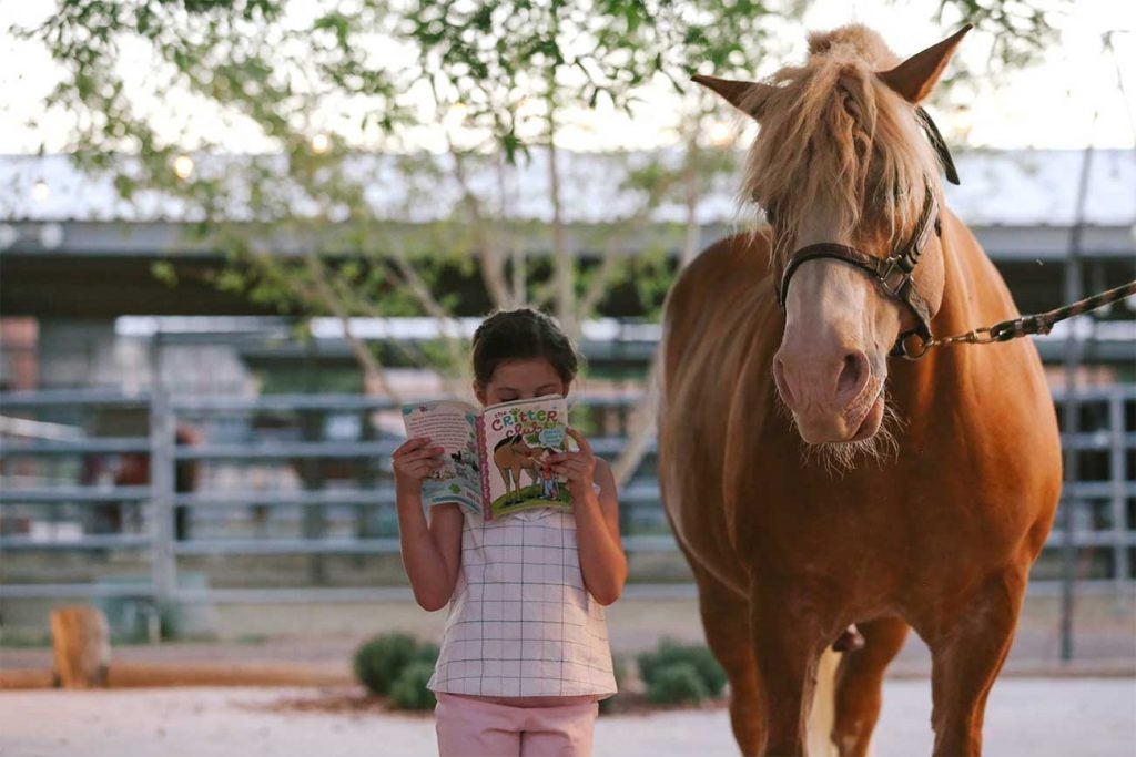 Makenzie reads up on her pal standing next to her.
