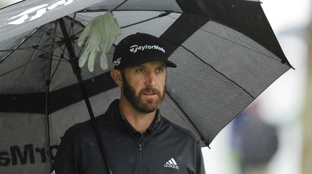 Dustin Johnson holds an umbrella during the final round of the Players Championship.