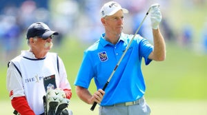 Jim Furyk and "Fluff" look over a shot on Sunday at the Players Championship.