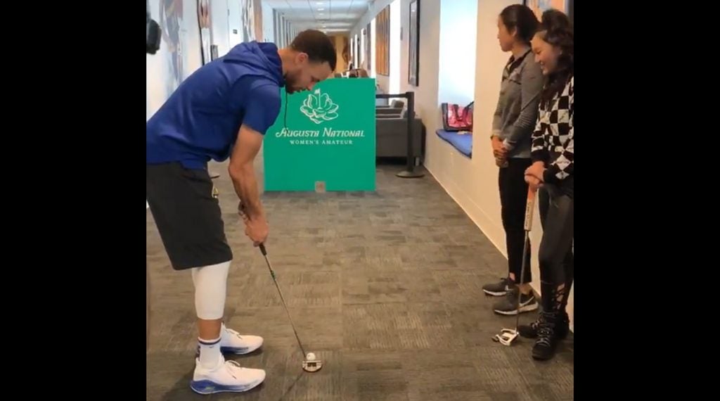 Steph Curry takes his shot during a putting contest with Augusta National Women's Amateur players