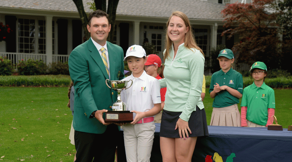 Kupcho poses with Patrick Reed and Angela Zhang at the Drive, Chip & Putt Championship at Augusta National.