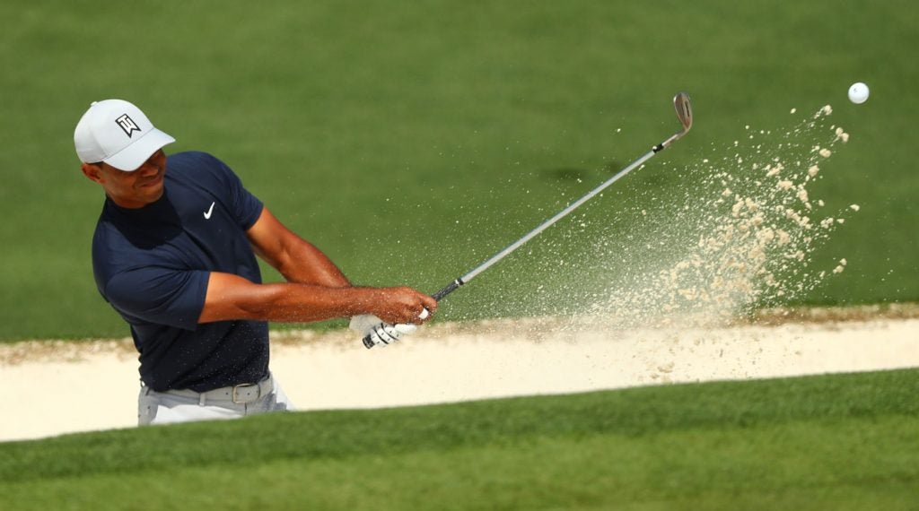 Tiger Woods hits a bunker shot on the par-5 15th hole at Augusta National.