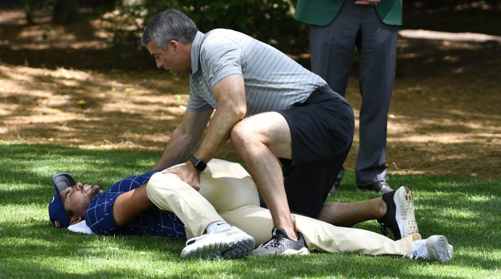 Jason Day getting stretched out by his trainer.