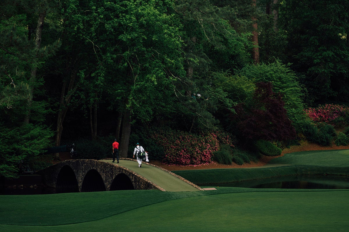 Tiger and Joe LaCava take a stroll over Hogan Bridge.