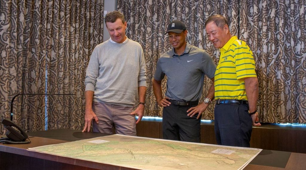 Gil Hanse (left), Tiger Woods (center) and Mr. Du Sha, owner and founder of Pacific Links International, look over course plans.