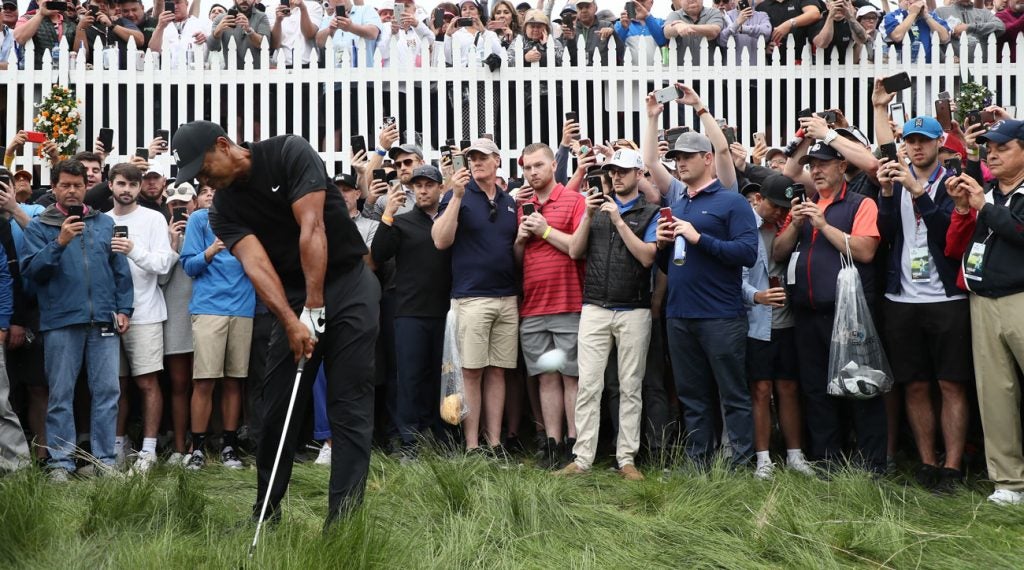 Tiger Woods takes a mighty swing from the heavy rough on the first hole at Bethpage Black.