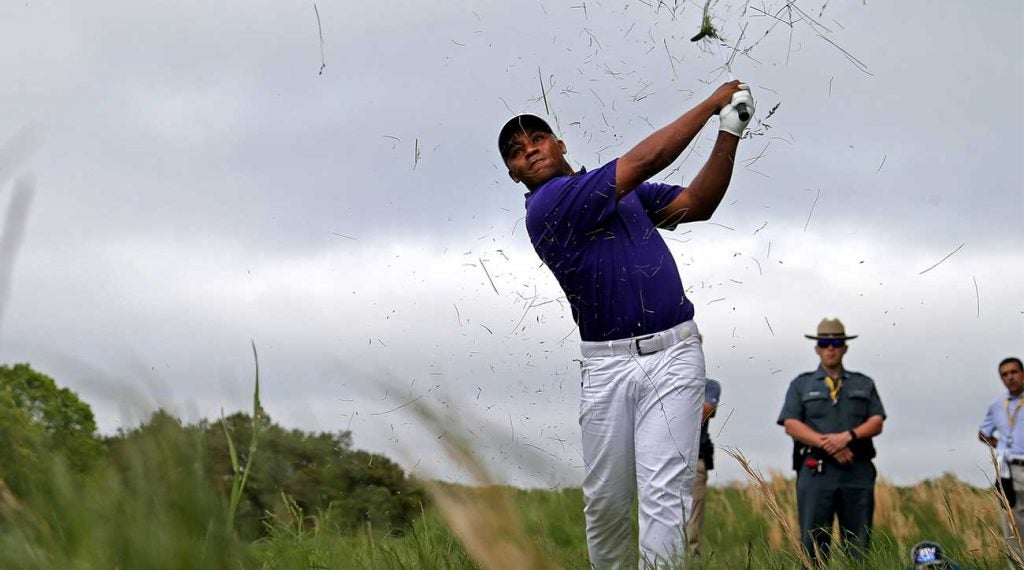 Harold Varner III hacks out of the rough during the 2019 PGA Championship.