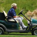 John Daly rides a cart during the first round of the 2019 PGA Championship.
