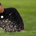 Tiger Woods blasts out of a bunker during a practice round at Bethpage Black on Tuesday.