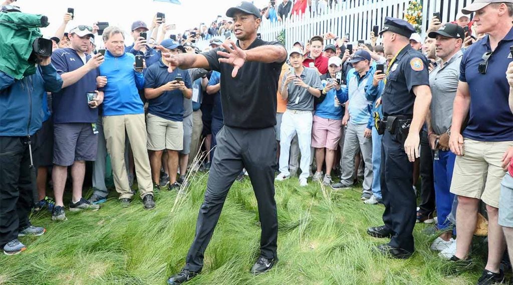 Tiger Woods tries to clear a path to the hole during his second round of the PGA Championship.