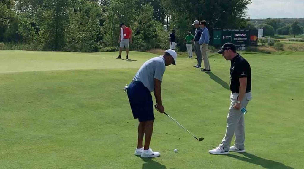 Tiger Woods, with Matt Killen looking on.