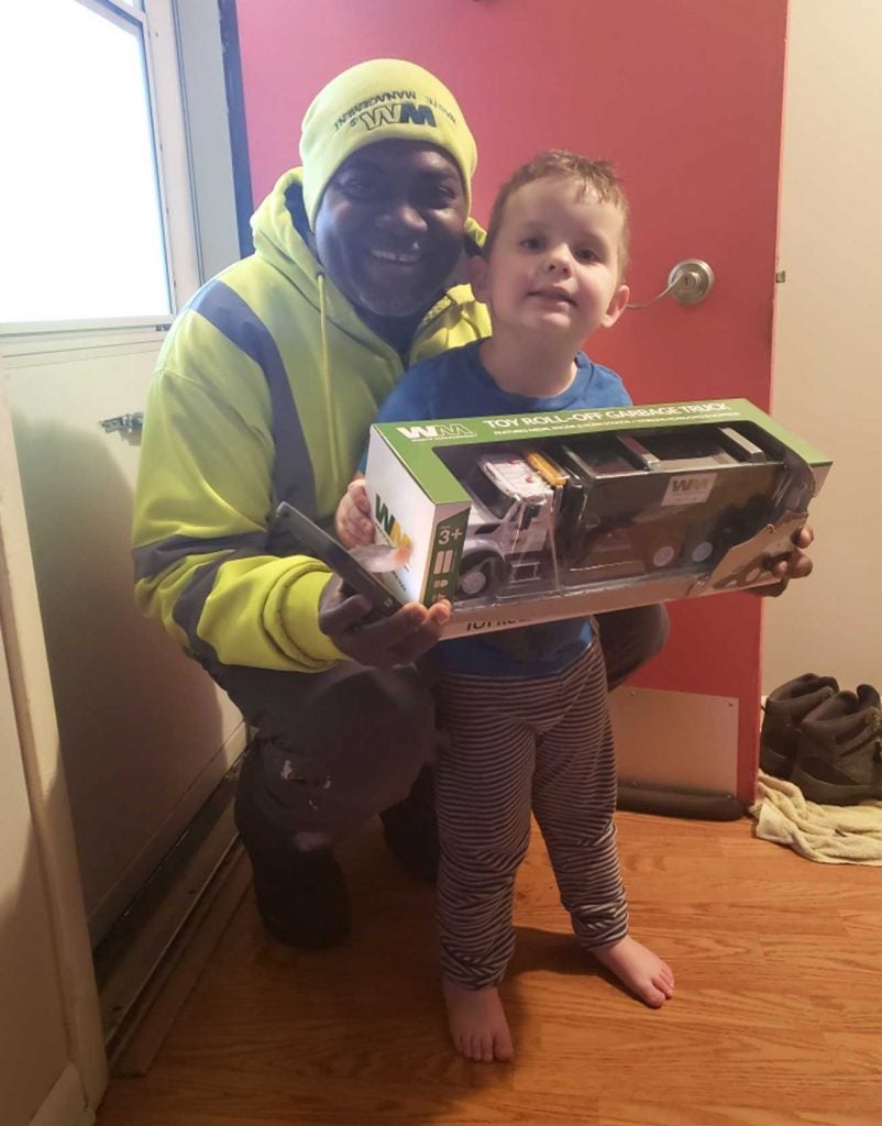 Anthony and Jackson pose for a picture with Jackson's garbage truck
