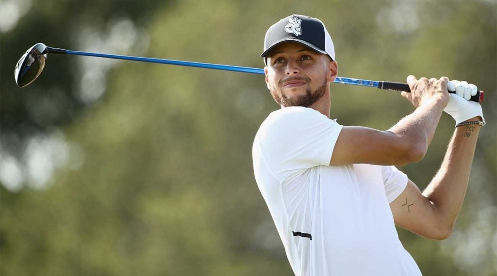 Steph Curry watches a tee shot.