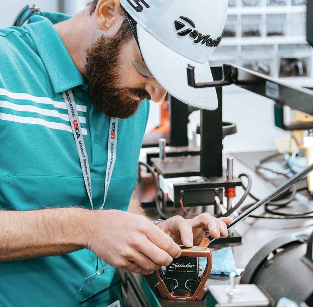A TaylorMade club technician works on a putter on the Tour truck.