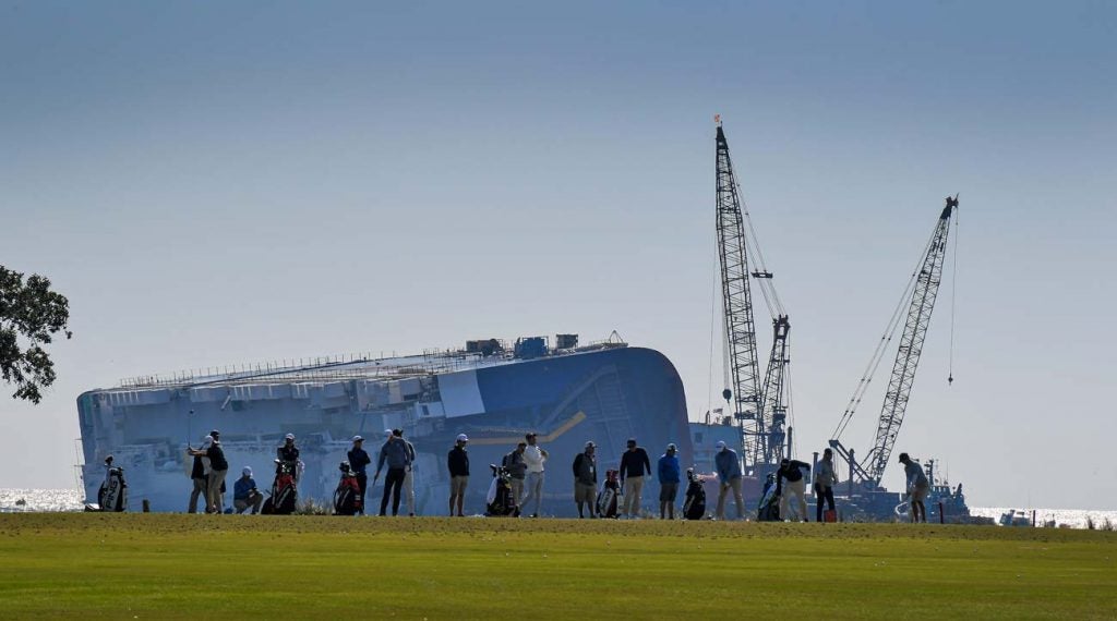 PGA Tour pros warm up on the range Wednesday with the massive capsized Golden Ray cargo ship looming in the background