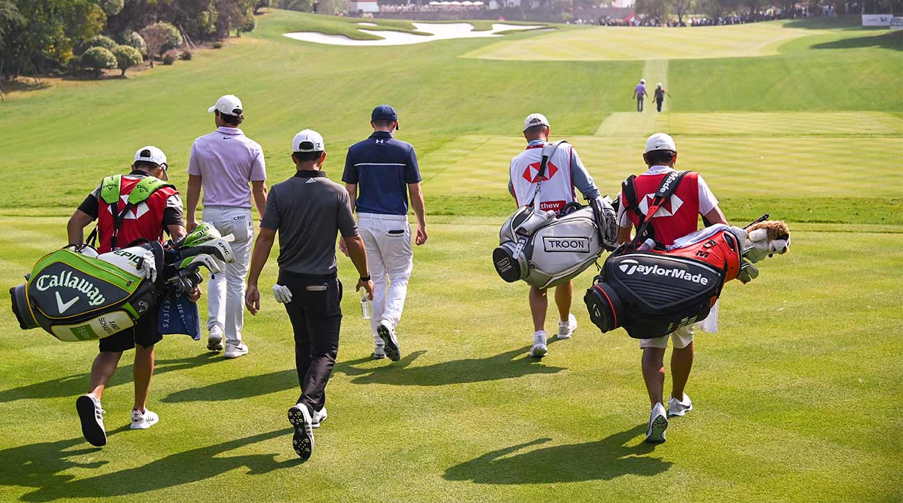 Golfers walk off the tee at a tournament.