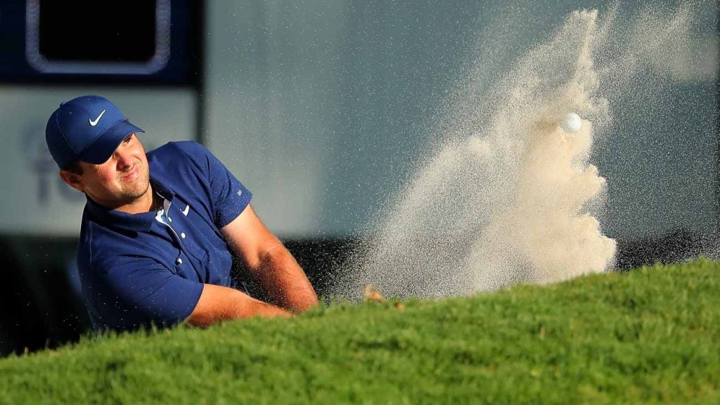 Patrick Reed hits a shot from the bunker on the 18th hole on Saturday.
