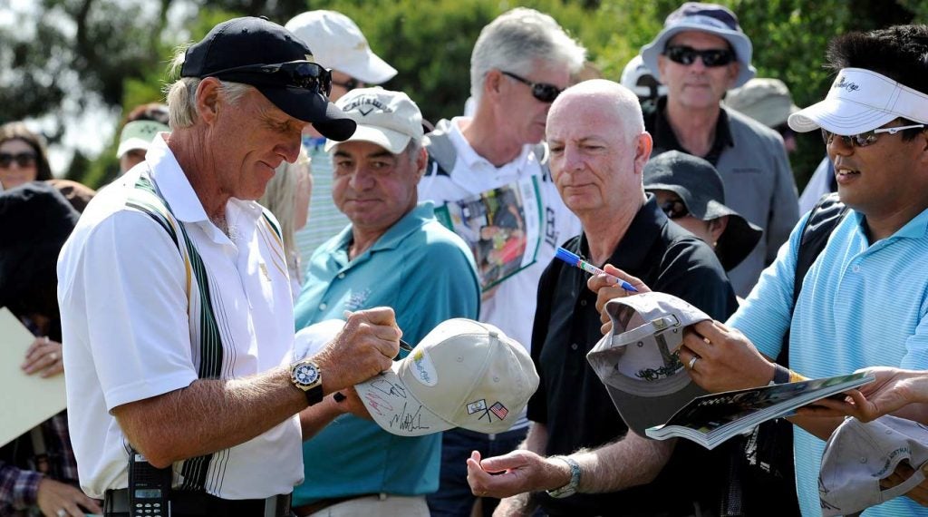 Greg Norman signs autographs for a fan at the Presidents Cup.