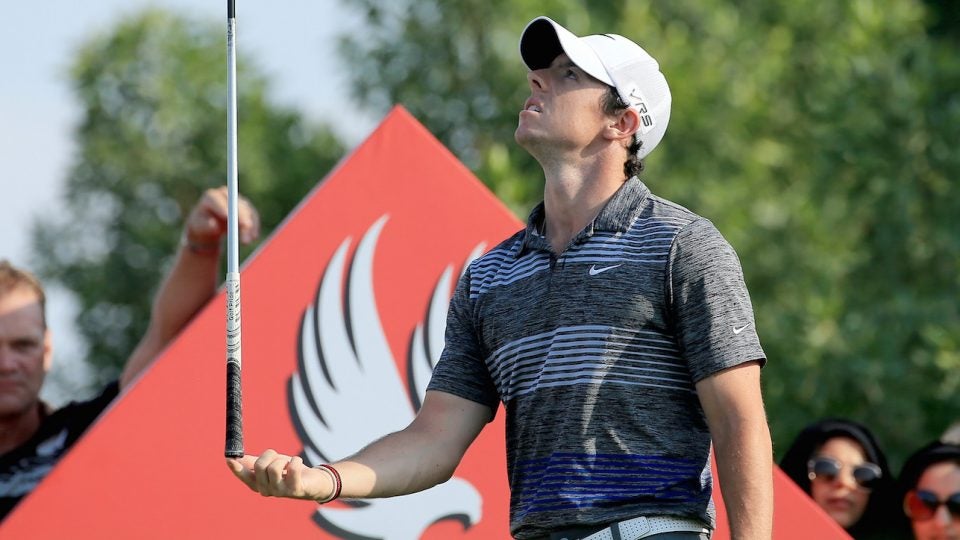 Rory McIlroy balances a golf club.