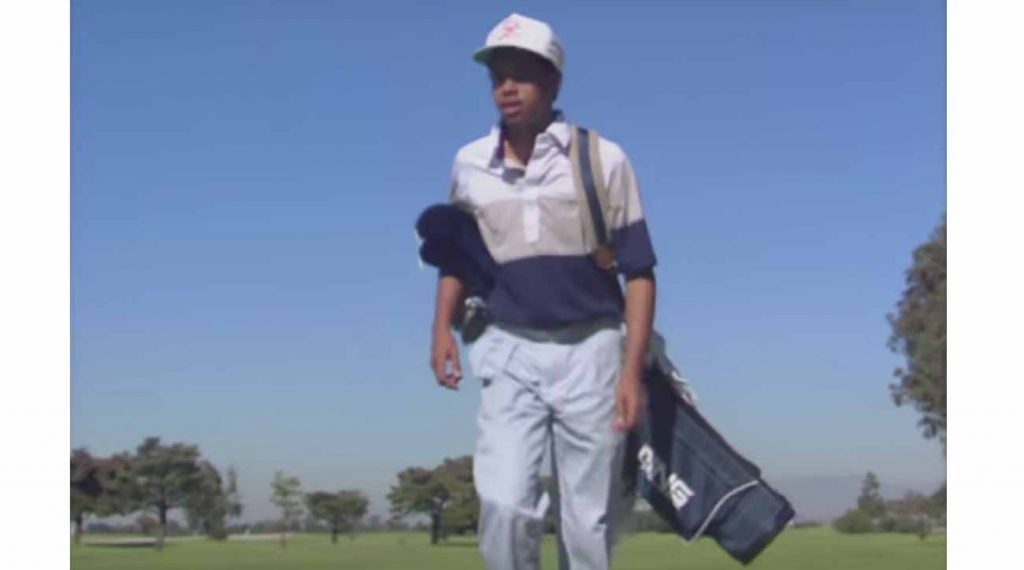 Tiger Woods lugs his Ping carry bag.