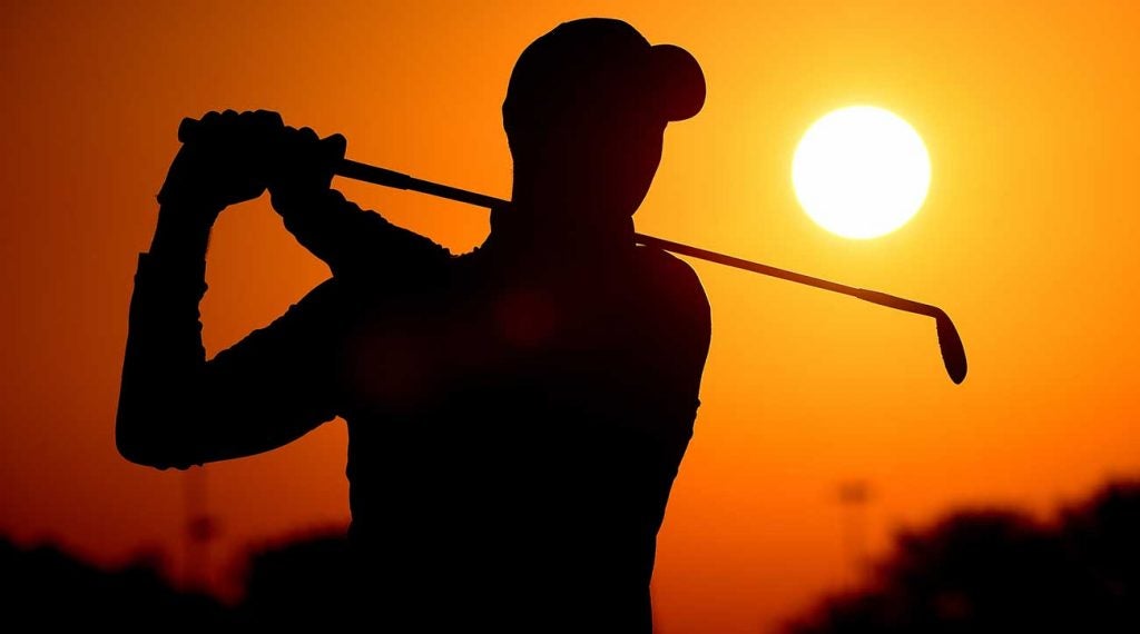 One golfer tee shot sunset