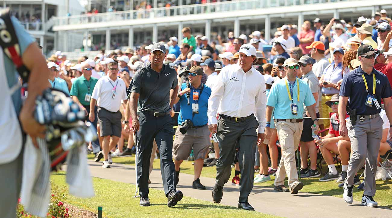 Tiger Woods and Phil Mickelson walk to the famed island green at TPC Sawgrass as hundreds of fans swarm.