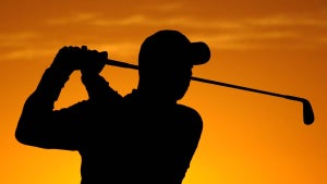 Golfer silhouetted at sunset