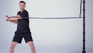 Man uses exercise band for rotational exercise