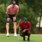 Tiger Woods and Peyton Manning line up a putt.