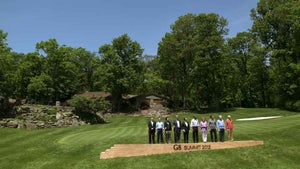 President Barack Obama and members of the 2012 G8 Summit stand near the Camp David golf hole.