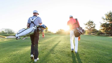 men carrying golf bags