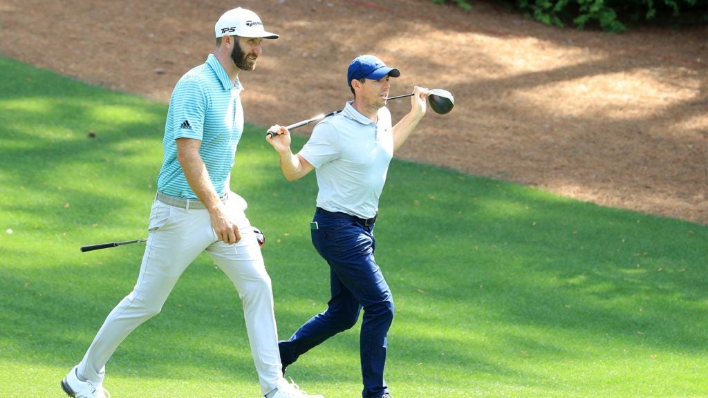 Dustin Johnson and Rory McIlroy walk down the fairway.