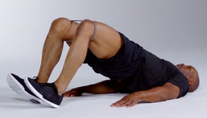 Man performs a glute bridge with an exercise band.