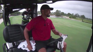 Tiger Woods rides in the golf cart.