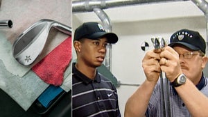 Mike Taylor and Tiger Woods look at golf irons
