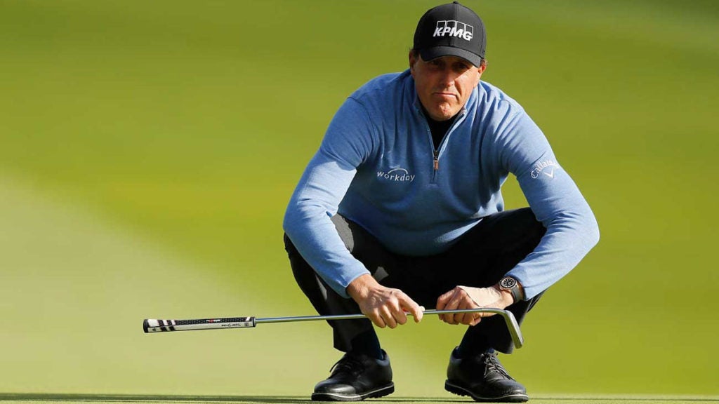 Phil Mickelson crouches on putting green