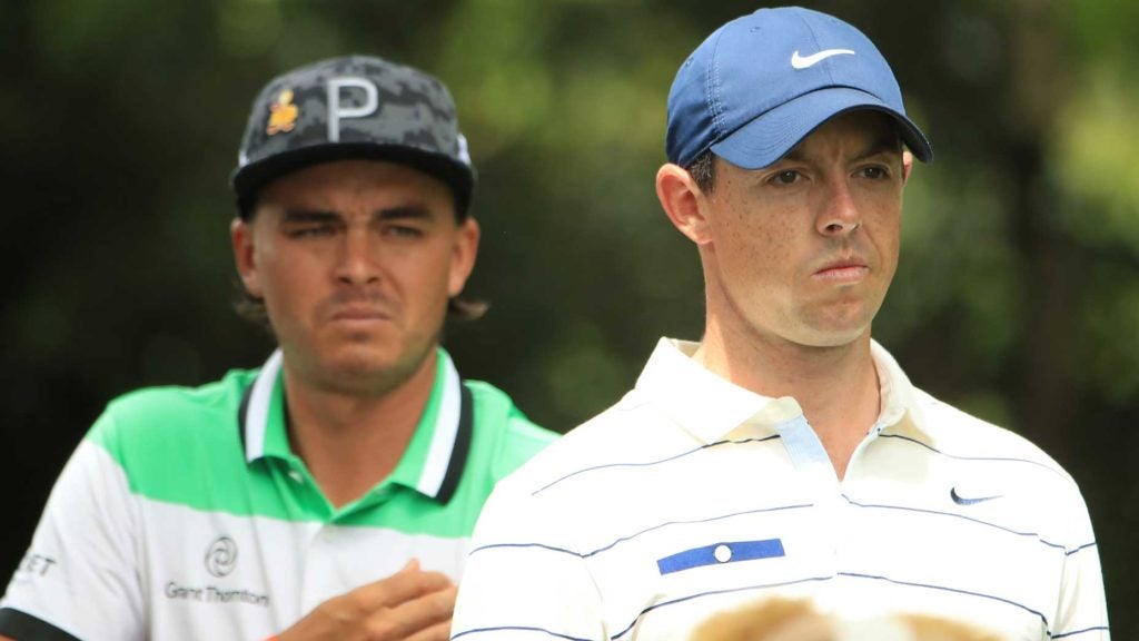 Rickie Fowler and Rory McIlroy watch golf ball