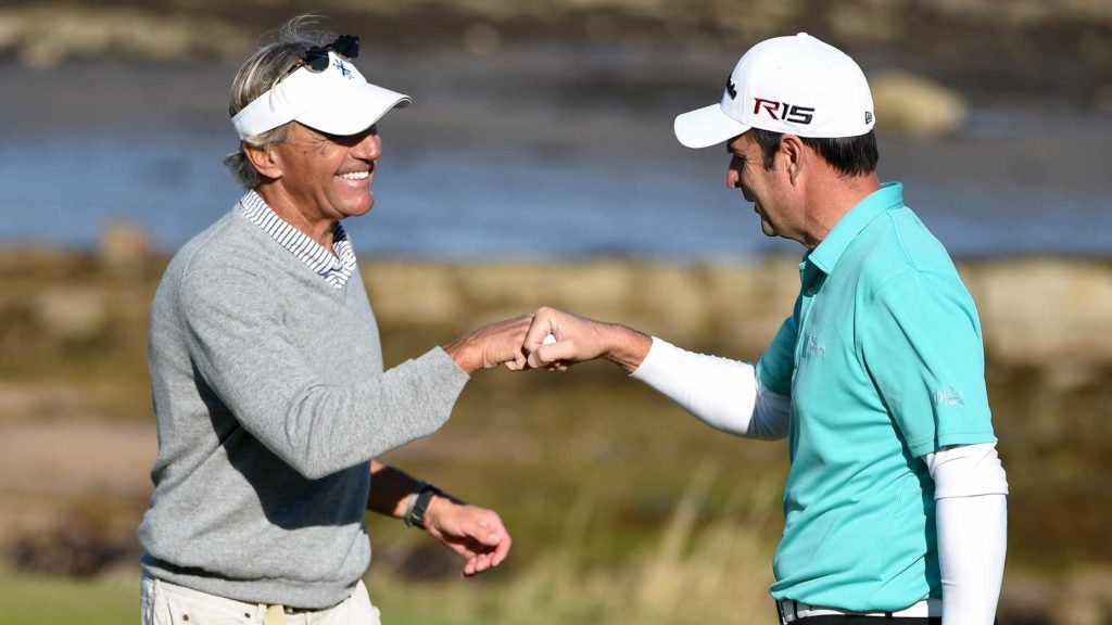 Seth Waugh and golfer fist-bump on golf green