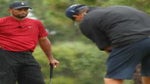 Tiger Woods watches Phil Mickelson putt on golf green