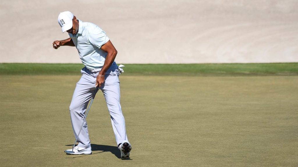 Tiger Woods pumps his first after making a putt.