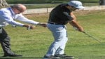 coach helps golfer on range