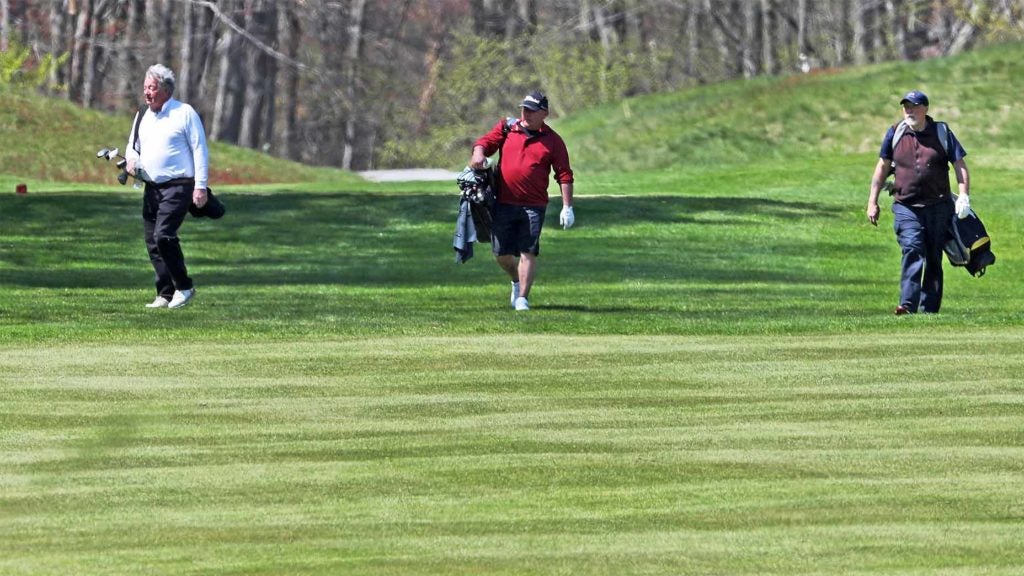 three golfers walking