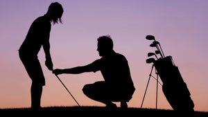 man gives golf swing lesson as sun sets